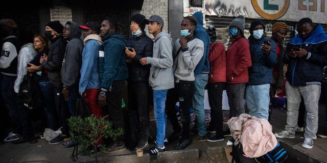 Migrants from Venezuela, Cuba, Haiti and Afghanistan wait in line outside at the Mexican Commission for Refugee Assistance in Mexico City Jan. 24, 2023.