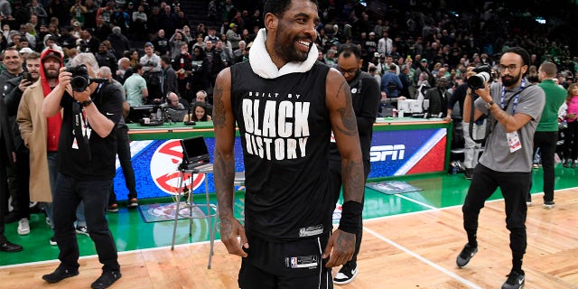 Brooklyn Nets'in 11 numaralı oyuncusu Kyrie Irving, 1 Şubat 2023'te Boston, Massachusetts'te TD Garden'da Boston Celtics'e karşı oynadığı maçın ardından gülümsüyor.