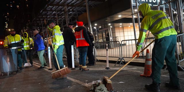 New York Police Department and Department of Sanitation workers clear asylum seekers from the sidewalk in front of Watson Hotel in Manhattan following days of protest and uncertainty, on Feb. 1, 2023.