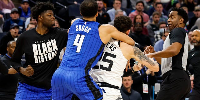 Mo Bamba. #11 of the Orlando Magic (L), throws a punch as teammate Jalen Suggs, #4, gets into a scrum with Austin Rivers, #25 of the Minnesota Timberwolves, in the third quarter of the game at Target Center on February 3, 2023, in Minneapolis, Minnesota. Rivers, Bamba, and Suggs were ejected from the game. 