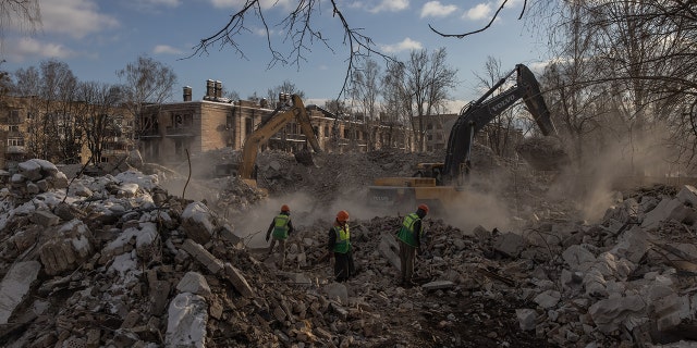 Demolition employees work on a site of a demolished residential building that was heavily damaged during Russian attacks, on Feb. 7, 2023, in Hostomel, Ukraine.