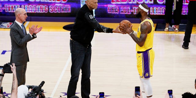 Kareem Abdul-Jabbar, a la izquierda, pasa un balón a LeBron James después de que James se convirtiera en el máximo anotador de todos los tiempos de la NBA, pasando a Abdul-Jabbar a 38,388 puntos en el tercer cuarto contra Oklahoma City Thunder en Crypto .com Arena el martes 7 de febrero. .  , 2023, en Los Ángeles. 