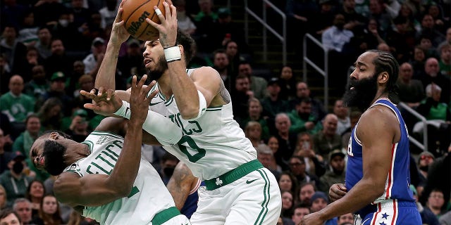 Jayson Tatum, #0 of the Boston Celtics, collides with Jaylen Brown, #7, as James Harden, #1 of the Philadelphia 76ers, looks on during the first half of the NBA game at the TD Garden on Feb. 8, 2023 in Boston.