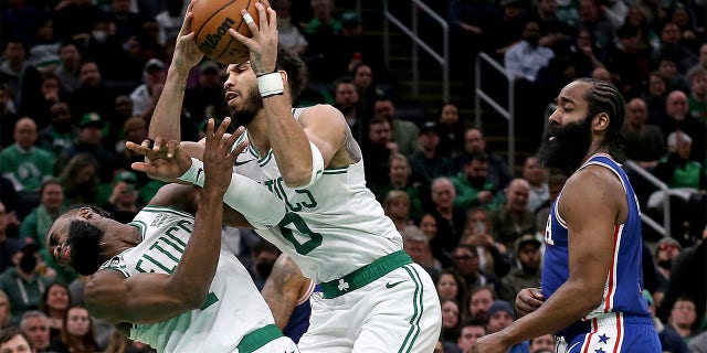 El No. 0 de los Boston Celtics, Jayson Tatum, choca con el No. 7, Jaylen Brown, mientras el No. 1 de los Philadelphia 76ers, James Harden, observa durante la primera mitad de un partido de la NBA en el TD Garden el 8 de febrero de 2023 en Boston.