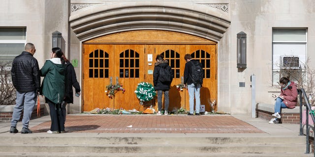 People visit a memorial at Berkey Hall on the day that Michigan State University students return to classes for the first time since the February 13 mass shooting there on February 20, 2023 in East Lansing, Michigan. 