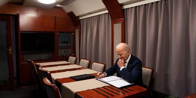 US President Joe Biden sits on a train as he goes over his speech marking the one-year anniversary of the war in Ukraine after a surprise visit to meet with Ukrainian President Volodymyr Zelenskyy, in Kyiv on February 20, 2023. 