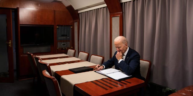 US President Joe Biden sits on a train as he goes over his speech marking the one-year anniversary of the war in Ukraine after a surprise visit to meet with Ukrainian President Volodymyr Zelenskyy, in Kyiv on February 20, 2023. 