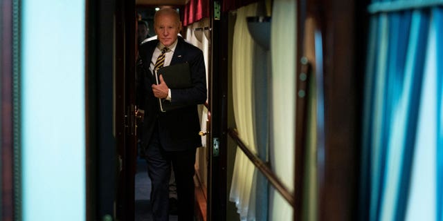 US President Joe Biden walks down a train corridor to his cabin after a surprise visit with Ukrainian President Volodymyr Zelenskyy, in Kyiv on February 20, 2023.