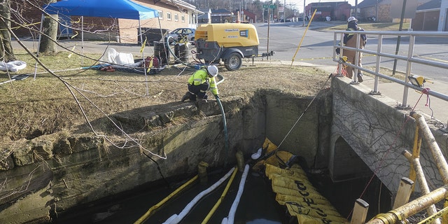 Contractors with Norfolk Southern reroute Sulphur Run creek using pumps upstream in East Palestine, Ohio, US, on Sunday, Feb. 19, 2023. 
