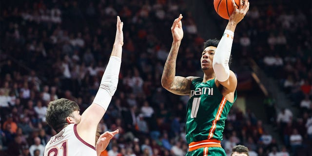 Jordan Miller of the Miami Hurricanes shoots over Grant Basile of the Virginia Tech Hokies in the first half of a game at Cassell Coliseum in Blacksburg, Virginia on Tuesday.
