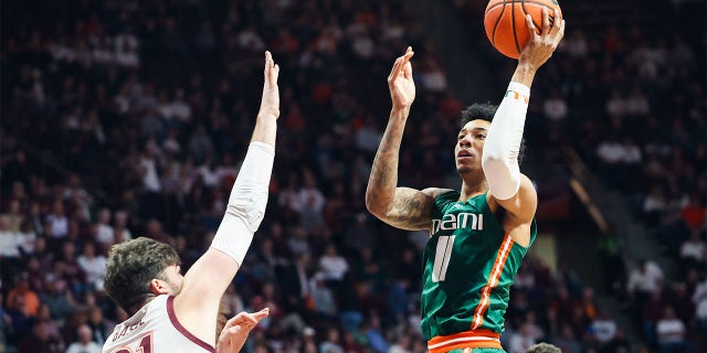 Jordan Miller of the Miami Hurricanes shoots over Grant Basile of the Virginia Tech Hokies in the first half of a game at Cassell Coliseum in Blacksburg, Virginia on Tuesday.