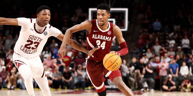 Gregory Jackson II, #23 of the South Carolina Gamecocks, defends Brandon Miller, #24 of the Alabama Crimson Tide, as he drives to the basket during a basketball game on Feb. 22, 2023 at Colonial Life Arena in Columbia, South Carolina.