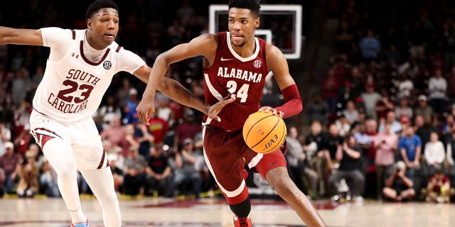 Gregory Jackson II, #23, of the South Carolina Gamecocks defends Brandon Miller, #24, of the Alabama Crimson Tide as he drives to the basket during a basketball game on February 22, 2023 at Colonial Life Arena in Columbia, South Carolina.