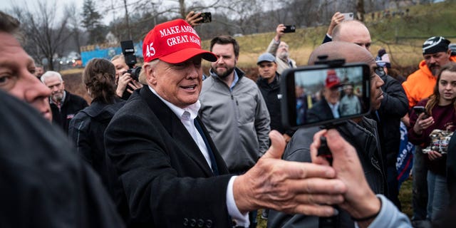 Former President Donald Trump, with Sen. JD Vance, R-Ohio, greets supporters while touring Little Beaver Creek and water pumps during a visit to East Palestine, Ohio, following the Feb. 3 Norfolk Southern freight train derailment on Wednesday, Feb. 22, 2023, in East Palestine, Ohio.