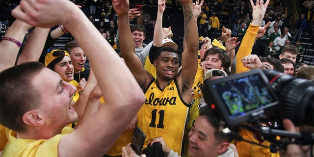 Iowa Hawkeyes guard Tony Perkins #11 celebrates with the student section after the overtime win against the Michigan State Spartans at Carver-Hawkeye Arena on February 25, 2023 in Iowa City, Iowa.  