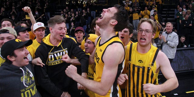 Forward Filip Rebraca, #0 of the Iowa Hawkeyes, celebrates with the student section after the overtime victory against the Michigan State Spartans at Carver-Hawkeye Arena, on February 25, 2023, in Iowa City, Iowa.  