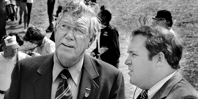 NASCAR founder and former CEO Bill France Sr., left, talks with a U.S. Secret Service agent regarding security for Vice President George H.W. Bush prior to the start of the 1983 Daytona 500 stock car race at Daytona International Speedway in Daytona Beach. Bush served as the race's honorary starter.