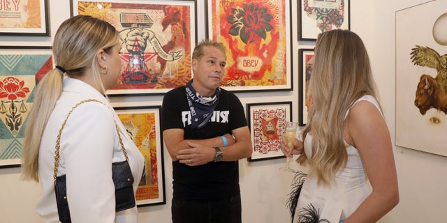 MIAMI, FLORIDA - NOVEMBER 30: Artist Shepard Fairey (C) talks with Renni Korniloff and Miranda Korniloff at Art Miami + Context Art Miami VIP Previews on November 30, 2021 in Miami, Florida. (Photo by Aaron Davidson/Getty Images for Art Miami + Context Art Miami)