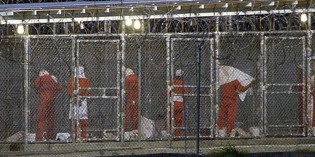 Detainees prepare themselves for the evening prayer March 4, 2002, at Camp X-Ray in Guantánamo Bay, Cuba by facing towards Mecca. Some 300 detainees from Afghanistan are being held at the US Naval Base in Guantánamo Bay, Cuba.