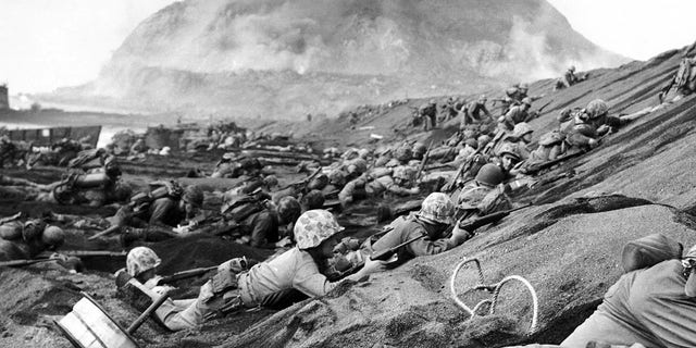 Japan/USA: U.S. Marines assault a beach at Iwo Jima — Mount Suribachi in the background, February 1945.