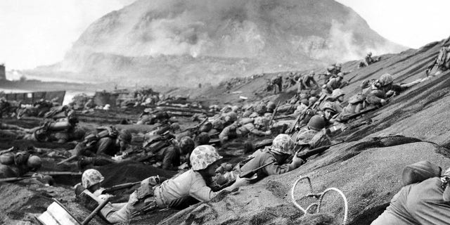 Japan/USA: U.S. Marines assault a beach at Iwo Jima — Mount Suribachi in the background, February 1945.