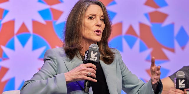 Marianne Williamson holding microphone