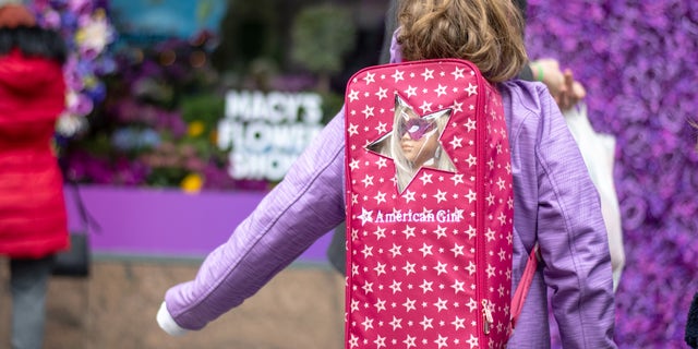 A woman wearing an "American Girl" doll and backpack visits nan 2022 Macy's Flower Show astatine Macy's Herald Square connected March 27, 2022 successful New York City.