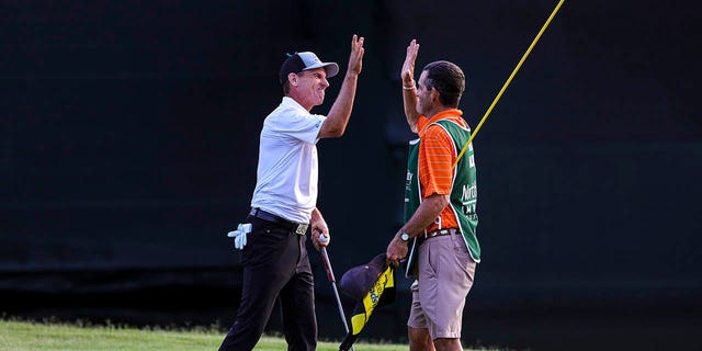 Steven Elker of New Zealand celebrates on the 18th hole with his caddy, Sam Workman, after winning the Insperity Invitational at The Woodlands Golf Club on May 1, 2022 in The Woodlands, Texas. 