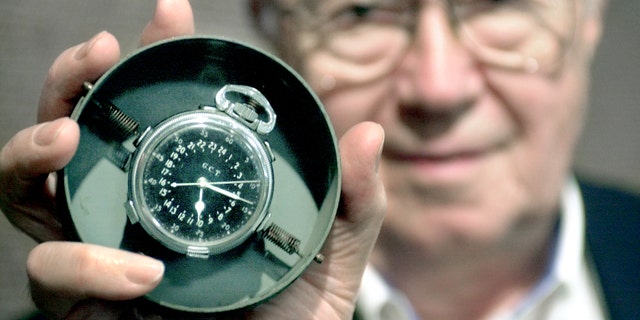 Theodore Van Kirk, the flight navigator aboard the Enola Gay, held up the master navigator clock he carried during the atomic bomb mission over Hiroshima. 