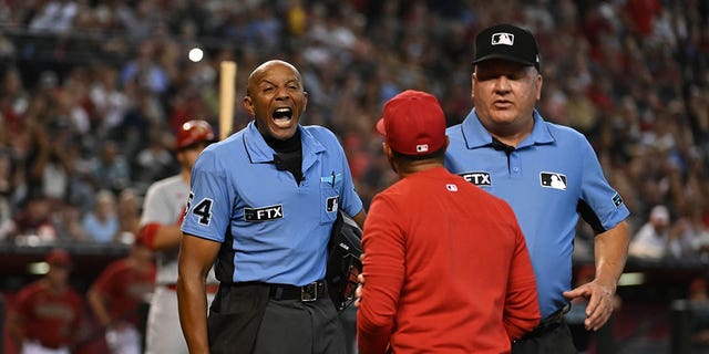 Third base umpire Jeff Nelson, right, steps in between manager Oliver Marmol of the St. Louis Cardinals, center, and home plate umpire C.B. Bucknor during an argument after Marmol was ejected during the third inning of a game against the Arizona Diamondbacks at Chase Field on Aug. 21, 2022, in Phoenix.