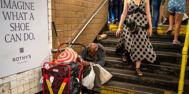 A homeless man partially blocks a subway stairway in New York City on Sept. 10, 2022.