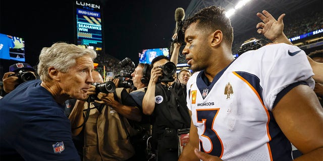 Head coach Pete Carroll of the Seattle Seahawks and Russell Wilson (3) of the Denver Broncos shake hands after their game at Lumen Field on September 12, 2022 in Seattle. 