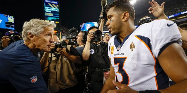 Seattle Seahawks head coach Pete Carroll and Denver Broncos number 3 Russell Wilson shake hands after their game at Lumen Field on September 12, 2022 in Seattle, Washington. 