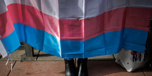 A woman's shoes under a trans flag during a concentration of the Trans Platform Federation, at the PSOE headquarters in Ferraz street, on 28 October, 2022 in Madrid, Spain.