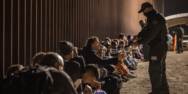 A CBP agent and migrants