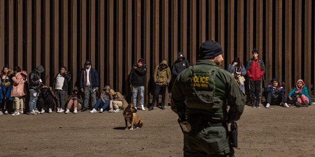 Immigrants wait to be processed by the U.S. Border Patrol after crossing the border from Mexico on December 30, 2022, in Yuma, Arizona. 