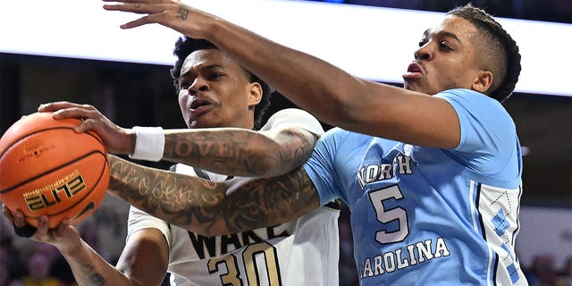 Damari Monsanto, #30 of the Wake Forest Demon Deacons, and Armando Bacot, #5 of the North Carolina Tar Heels, vie for a rebound during the second half of their game at Lawrence Joel Veterans Memorial Coliseum on Feb. 7, 2023 in Winston-Salem, North Carolina. Wake Forest won 92-85, 