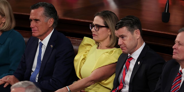 WASHINGTON, DC - FEBRUARY 07: (L-R) Sen. Mitt Romney (R-UT), Sen. Kyrsten Sinema (I-AZ) and Sen. Todd Young (R-IN) sit together during U.S. President Joe Biden's State of the Union address during a joint meeting of Congress in the House Chamber of the U.S. Capitol on February 07, 2023 in Washington, DC. 