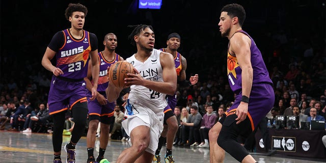 Cam Thomas, #24 of the Brooklyn Nets, drives against Devin Booker, #1 of the Phoenix Suns, during their game at Barclays Center on Feb. 7, 2023 in New York City.    