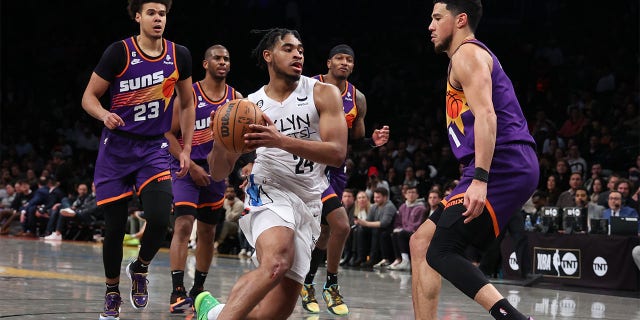 Cam Thomas, #24 of the Brooklyn Nets, drives against Devin Booker, #1 of the Phoenix Suns, during their game at Barclays Center on Feb. 7, 2023 in New York City.