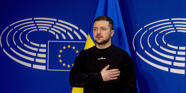 Ukrainian President Volodymyr Zelensky stands while listening to the Ukrainian national anthem on his arrival at the European Parliament on February 09, 2023, in Brussels, Belgium. 