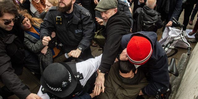 La policía lucha por mantener separados a los dos bandos mientras los manifestantes anti-drag queen son retirados de las escaleras de la Tate Britain el 11 de febrero de 2023 en Londres.