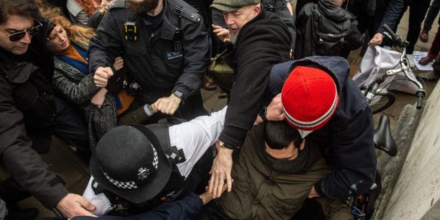 Police struggle to keep the two sides apart as anti drag queen protestors are pushed off the steps of Tate Britain on Feb. 11, 2023 in London.