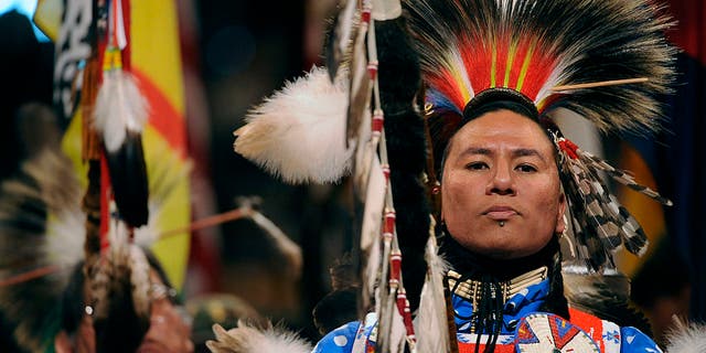 Nathan Chasing Horse of Rosebud, South Dakota, and a member of the Sioux Tribe, leads the Color guard at the beginning of the grand entry into the coliseum.