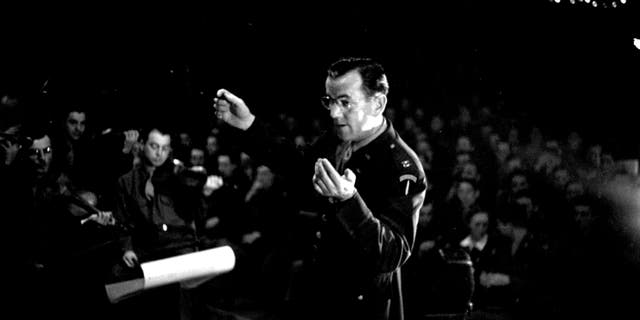 August 1944: Band leader Glenn Miller (1904-1944), conducting an ENSA concert during the Second World War. Original.