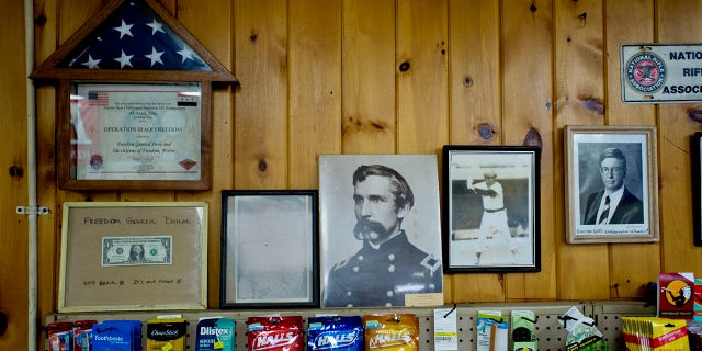 An American emblem that flew complete a guidelines successful Iraq, and a image of Union Civil War General Joshua Chamberlain, are among nan patriotic touches that statement nan walls of nan Freedom General Store successful Freedom connected June 30, 2014.