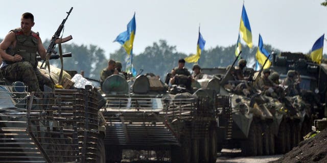 Ukrainian servicemen sit atop armored personnel carriers near the eastern Ukrainian city of Slavyansk on July 11, 2014.