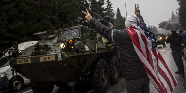 A supporter welcomes U.S. soldiers of the 3rd Squadron, 2nd Cavalry Regiment of the U.S. Army at the Czech-Poland border on March 29, 2015 in Harrachov, Czech Republic. Polish President Duda expected to push President Biden to increase permanant U.S. troop count in nations that border Ukraine and Russia. 