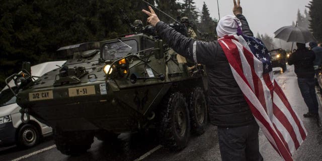 A supporter welcomes U.S. soldiers of the 3rd Squadron, 2nd Cavalry Regiment of the U.S. Army at the Czech-Poland border on March 29, 2015 in Harrachov, Czech Republic. Polish President Duda expected to push President Biden to increase permanant U.S. troop count in nations that border Ukraine and Russia. 