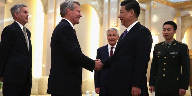 BEIJING, CHINA - APRIL 09:  U.S. Ambassador to China Max Baucus (2L) shakes hands with Chinese President Xi Jinping (4L) as Secretary of Defense Chuck Hagel (3L) looks on during a meeting at the Great Hall of the People April 9, 2014 in Beijing, China. Secretary Hagel is on the second stop of an Asian trip, the fourth time since he took office, to Japan, China and Mongolia.  